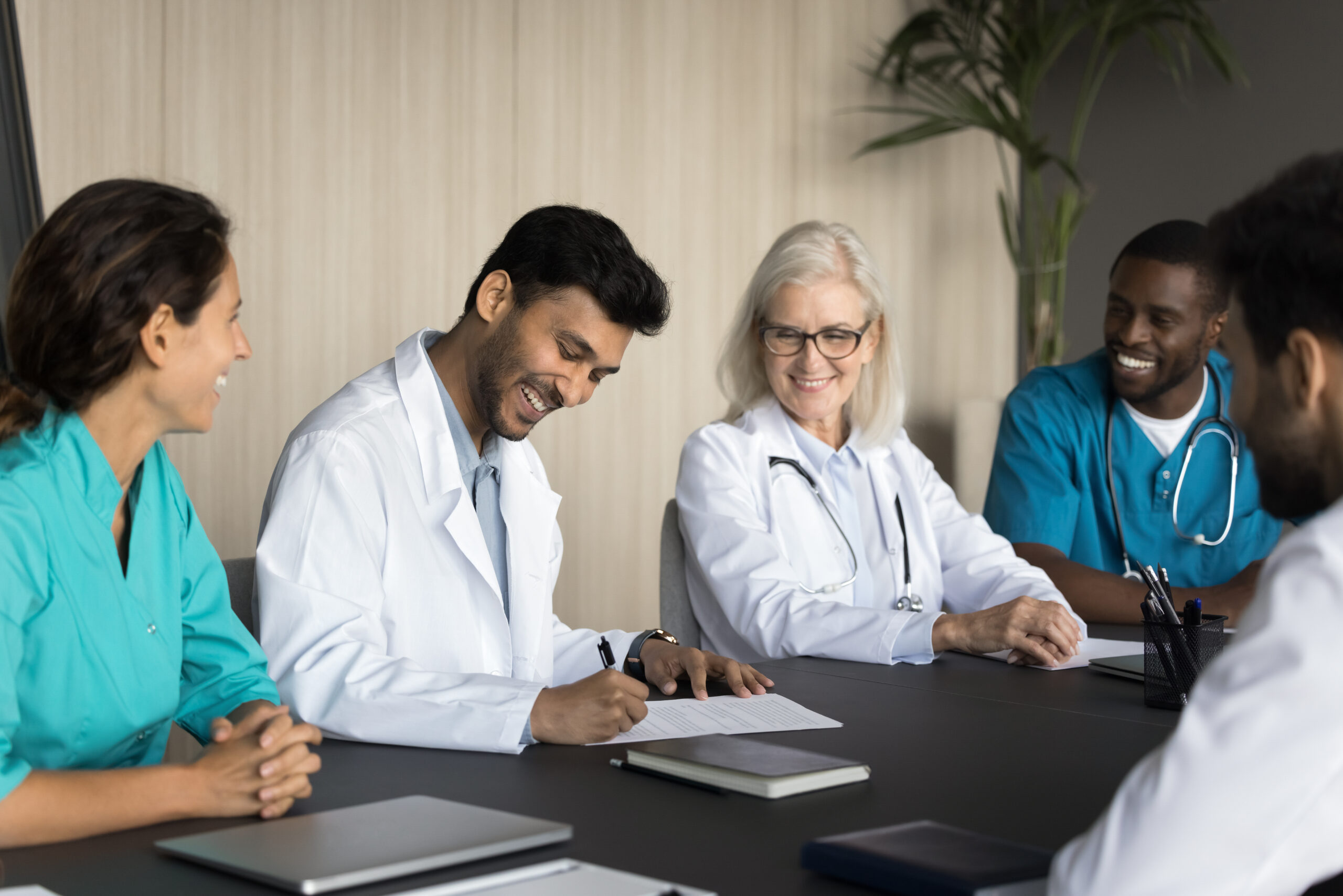 Diverse group of people sitting around table.