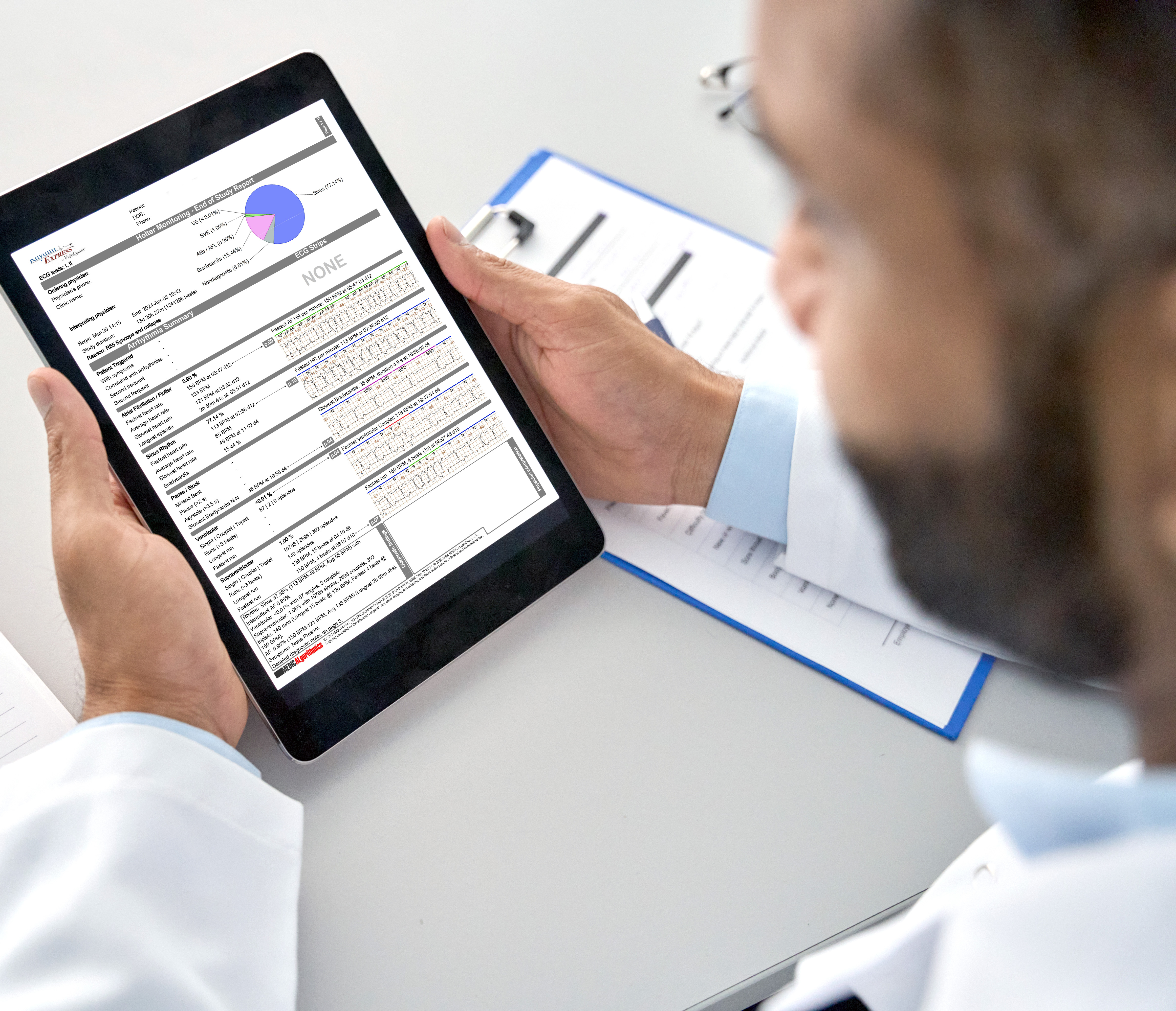 Male doctor holding digital tablet in hands looking at report screen.